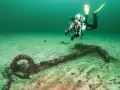 Taucher erkundet ein altes Ankerwrack in der Ostsee.
