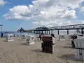 Strandkörbe am Zirchow Strand, mit Seebrücke und Wolkenhimmel.