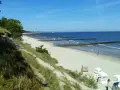 Sonniger Strand Zempin mit Dünen, Wellenbrechern und Strandkörben.