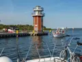 Plau am See: Leuchtturm und Promenade mit Booten. Ein Fahrrad wartet auf dem Vorderdeck.