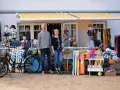 Ein Paar vor einem Laden mit Strandartikeln. Sie sind bereit, juliusruh einkaufen zu gehen und haben alles für einen schönen Tag am Meer.