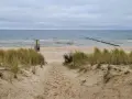 Pfad durch Dünen zum Strand Bansin. Das Meer ist ruhig, der Himmel bedeckt.
