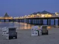 Strandkörbe am Abend vor der beleuchteten Seebrücke in Heringsdorf. Ein perfekter Ort für Geheimtipps am Meer.