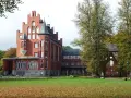 Das imposante Schloss Kalkhorst, ein Backsteinbau mit Türmchen und Erkern, steht im Herbstlicht.