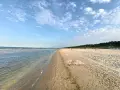 Sonniger Karlshagen Strand mit sanften Wellen und weitem Sand. Ein perfekter Ort für entspannte Tage am Meer.
