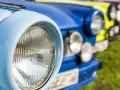 Bunte Oldtimer reihen sich auf einer Wiese bei einem Oldtimertreffen in Mecklenburg-Vorpommern.