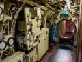 Blick in das Innere des U-Bootes U 461. Messinstrumente, Rohre und ein Notausgangsschild sind zu sehen.