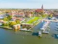 Blick auf Barth an der Ostsee mit Yachthafen, Wohnmobilstellplätzen und modernen Ferienhäusern am Wasser.