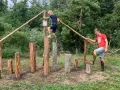 Junge und Mann balancieren auf Baumstämmen im Kletterpark Plau am See.