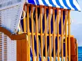 Strandkorb mit blau-weißen Streifen, ein Ort der Ruhe und des Kunst offen.