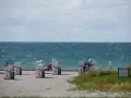 Strandkörbe am Bojendorfer Strand laden zum Entspannen ein. Das Meer glitzert, die Wolken ziehen vorbei.
