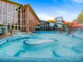 Einladende Therme an der Ostsee mit großem Pool und bunten Wasserrutschen im Hintergrund.