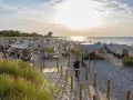 Sommerliche Ostsee Party mit vielen Gästen, Strandkörben und Zelten am Abend.