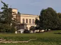 Prachtvolles Gebäude in der **Putbus Altstadt** mit Kirchturm und großen Rundbogenfenstern, umgeben von Bäumen und einer grünen Wiese.