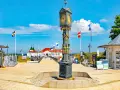 Prachtvoller Uhrenturm im Ahlbeck Zentrum, flankiert von Souvenirbuden und wehenden Flaggen.
