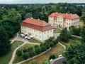 Zwei gelbe Barockschlösser mit roten Dächern auf der Schlossinsel Mirow, umgeben von üppigem Grün und gepflegten Wegen.