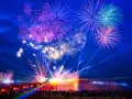 Spektakuläres Feuerwerk und Lichtshow an der Ostsee. Menschen feiern Silvester mit einer ausgelassenen Party am Strand.