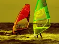 Zwei Windsurfer mit bunten Segeln auf dem Meer. Ein tolles Erlebnis für Surf und Segel Hiddensee.