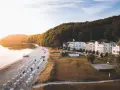 Sonnenuntergang am Binz Strand mit vielen Strandkörben, weißen Villen und einem dichten Wald.