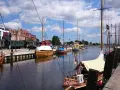 Boote im Greifswald Hafen liegen neben historischen Zügen.