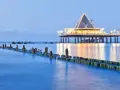 Ein beleuchteter Pier mit Restaurant und Wellenbrechern im Meer. Perfekt für einen Heringsdorf Urlaub.