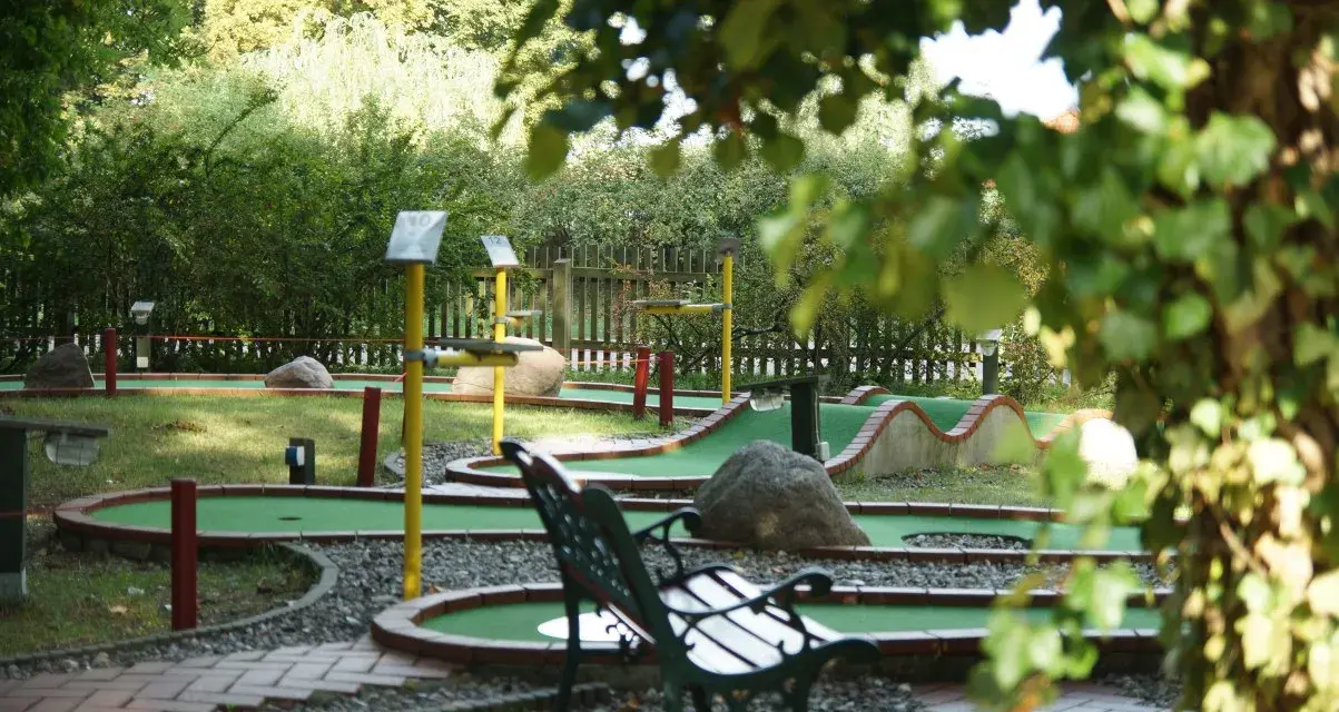 Minigolf Koserow: grüne Bahnen mit Hindernissen und Bänken laden zum Spiel ein.