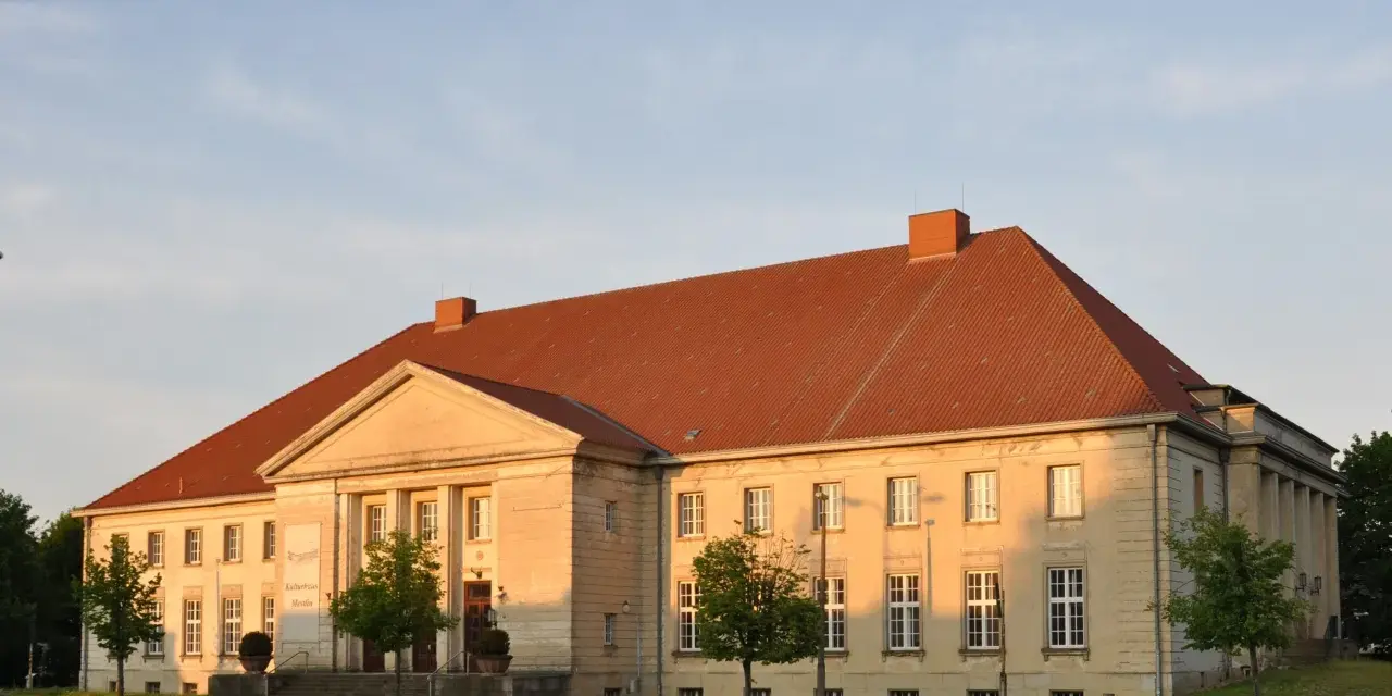 Die Orangerie Ludwigslust, ein Kulturhaus, erstrahlt im warmen Abendlicht.