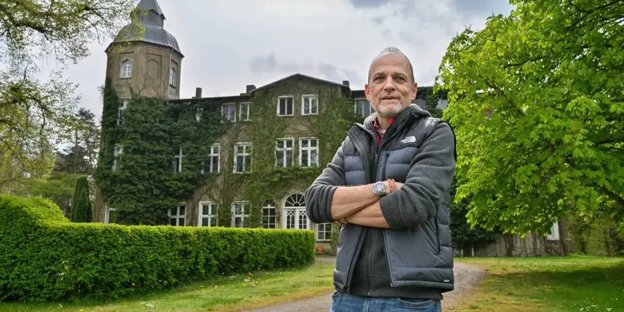 Mann vor dem historischen Gutshaus Wesselstorf, das von Efeu umrankt ist.