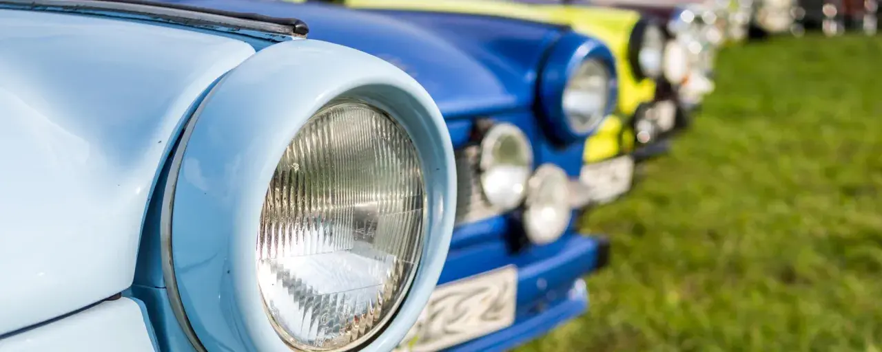 Bunte Oldtimer reihen sich auf einer Wiese bei einem Oldtimertreffen in Mecklenburg-Vorpommern.