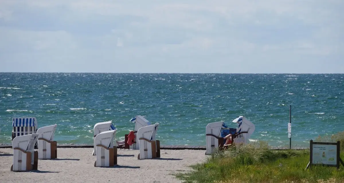 Strandkörbe am Bojendorfer Strand laden zum Entspannen ein. Das Meer glitzert, die Wolken ziehen vorbei.