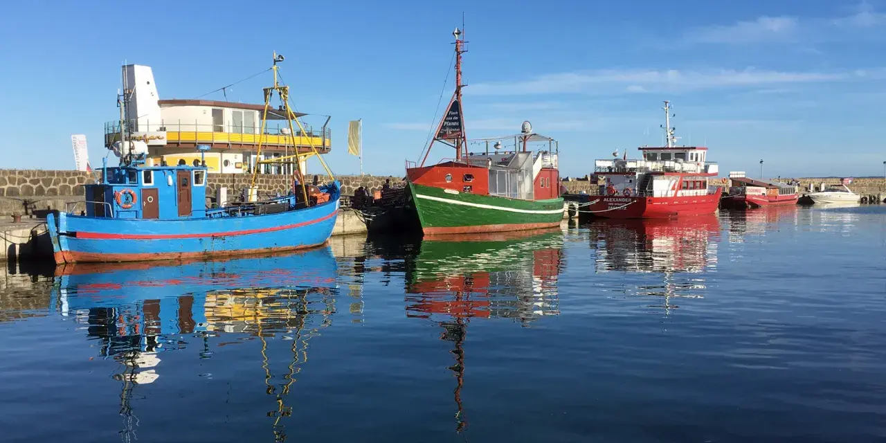 Boote im Hafen von Sassnitz Altstadt spiegeln sich im ruhigen Wasser.