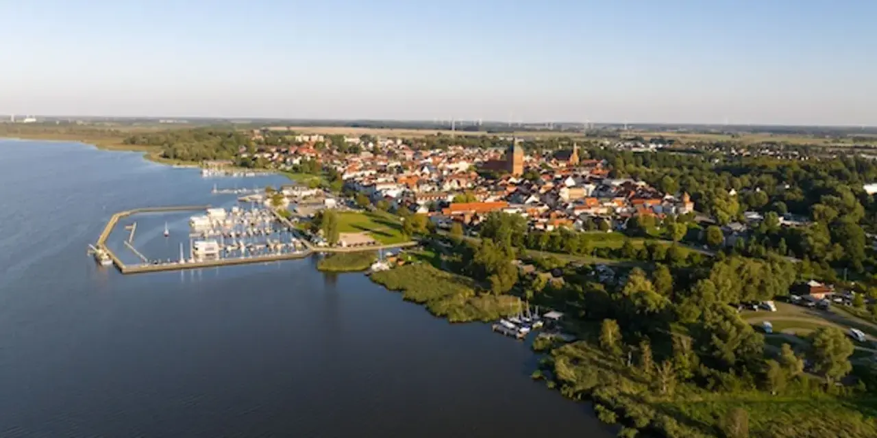Luftaufnahme des Ribnitz-Damgarten Hafens mit vielen Segelbooten und der Stadt im Hintergrund.