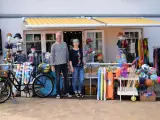 Ein Paar vor einem Laden mit Strandartikeln. Sie sind bereit, juliusruh einkaufen zu gehen und haben alles für einen schönen Tag am Meer.