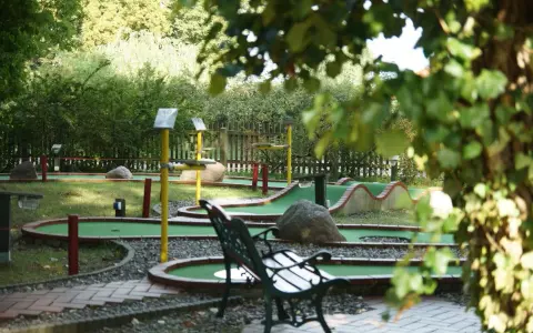 Minigolf Koserow: grüne Bahnen mit Hindernissen und Bänken laden zum Spiel ein.
