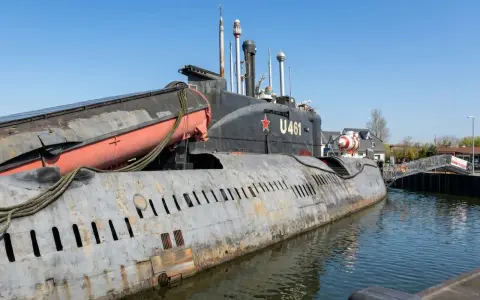 Ein sowjetisches U-Boot, die U 461, liegt im Hafen an der Ostsee. Eine Rettungsboot hängt an der Seite.