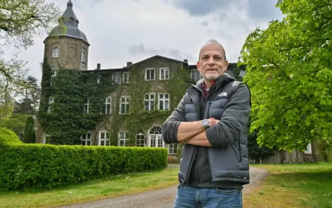 Mann vor dem historischen Gutshaus Wesselstorf, das von Efeu umrankt ist.