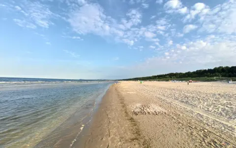 Sonniger Karlshagen Strand mit sanften Wellen und weitem Sand. Ein perfekter Ort für entspannte Tage am Meer.