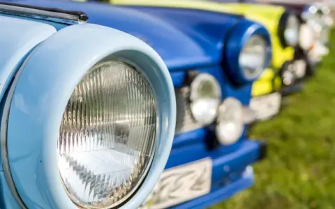 Bunte Oldtimer reihen sich auf einer Wiese bei einem Oldtimertreffen in Mecklenburg-Vorpommern.