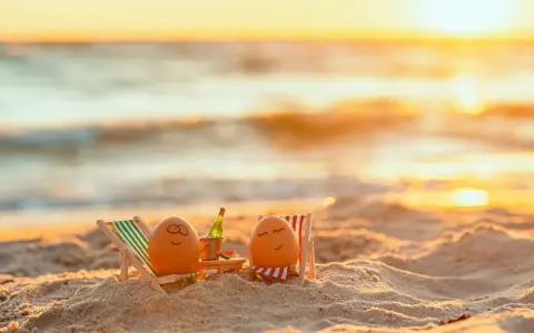 Zwei bemalte Eier entspannen sich in Liegestühlen am Strand bei Sonnenuntergang. Eine Flasche Sekt steht bereit. Eine süße Idee für Veranstaltungen an Ostern.