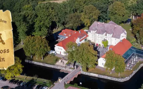 Luftaufnahme des Wasserschlosses Mellenthin mit Wassergraben, Brücke und umliegendem Park. Der Eintritt ist frei zugänglich.