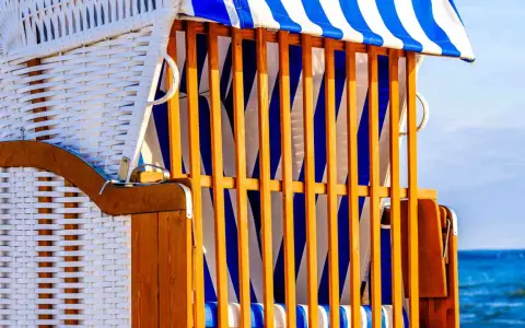 Strandkorb mit blau-weißen Streifen, ein Ort der Ruhe und des Kunst offen.