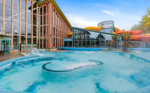 Einladende Therme an der Ostsee mit großem Pool und bunten Wasserrutschen im Hintergrund.