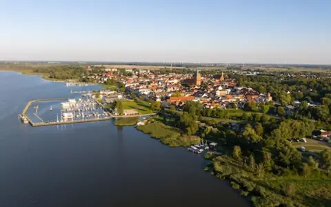 Luftaufnahme des Ribnitz-Damgarten Hafens mit vielen Segelbooten und der Stadt im Hintergrund.