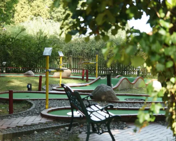Minigolf Koserow: grüne Bahnen mit Hindernissen und Bänken laden zum Spiel ein.