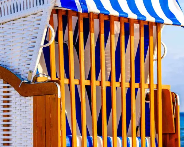 Strandkorb mit blau-weißen Streifen, ein Ort der Ruhe und des Kunst offen.