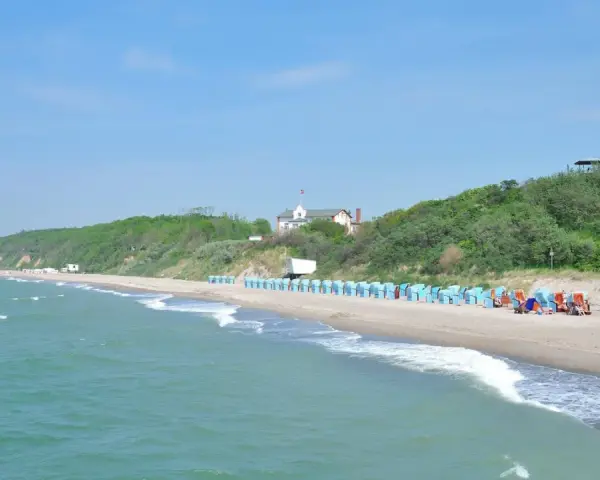 Strand mit Strandkörben und grünen Hügeln. Hier finden Sie Rerik Geheimtipps für einen entspannten Urlaub an der Ostsee.