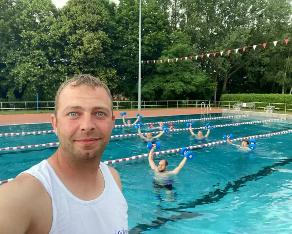 Wassergymnastik im Lindenbad Pasewalk: Eine Gruppe trainiert mit blauen Hanteln im Pool.