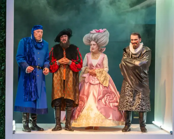 Vier Darsteller in historischen Kostümen bei den Vineta Festspielen Zinnowitz. Ein Mann in Blau, ein Mann in Rot-Schwarz, eine Frau in Rosa und ein Mann in Grau.