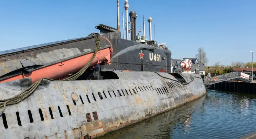 Ein sowjetisches U-Boot, die U 461, liegt im Hafen an der Ostsee. Eine Rettungsboot hängt an der Seite.