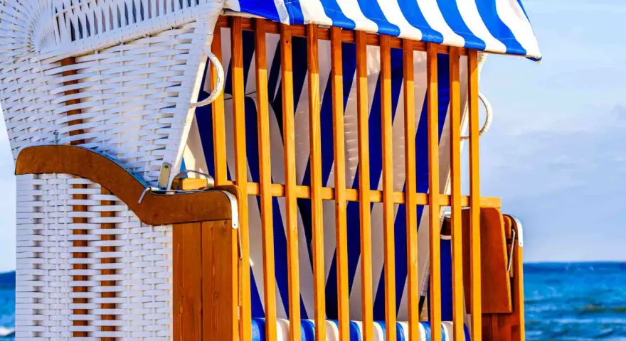 Strandkorb mit blau-weißen Streifen, ein Ort der Ruhe und des Kunst offen.